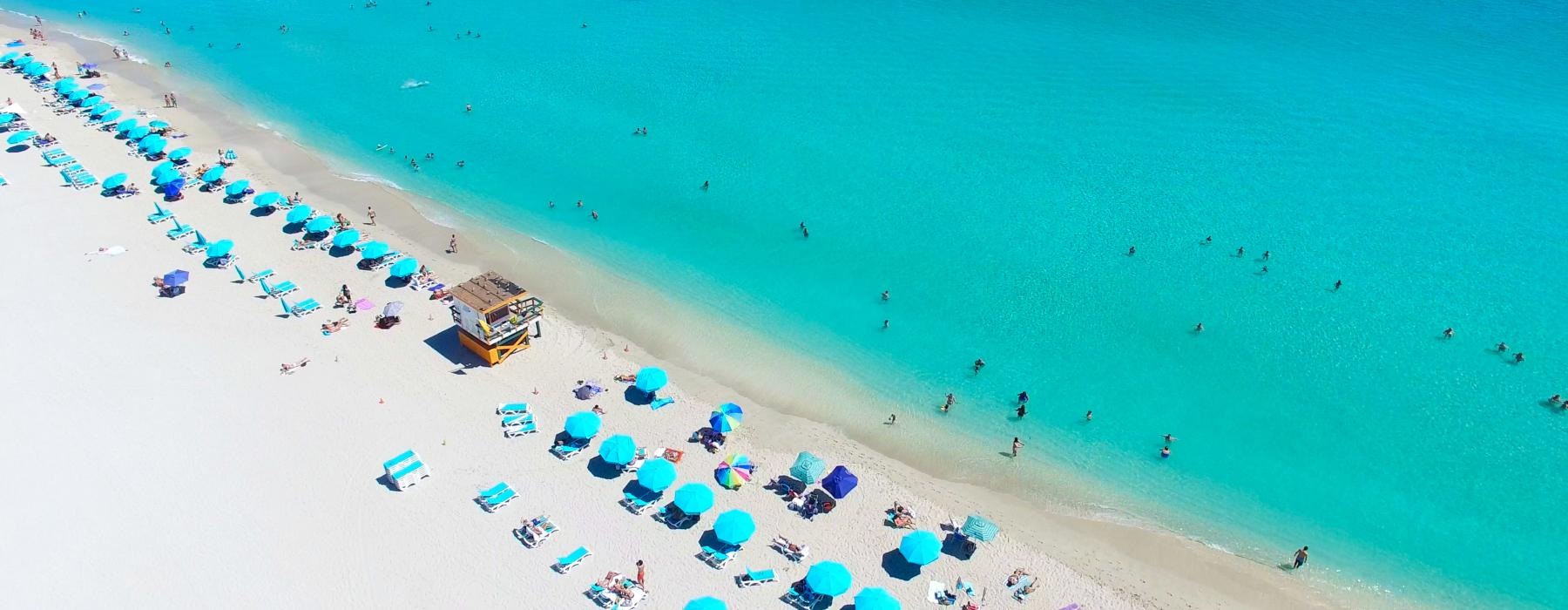 a beach with people and umbrellas