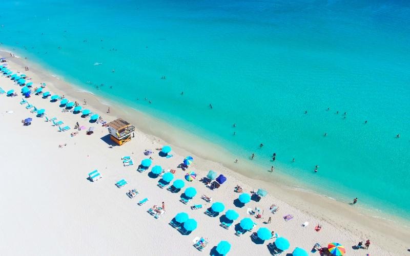 a beach with people and umbrellas