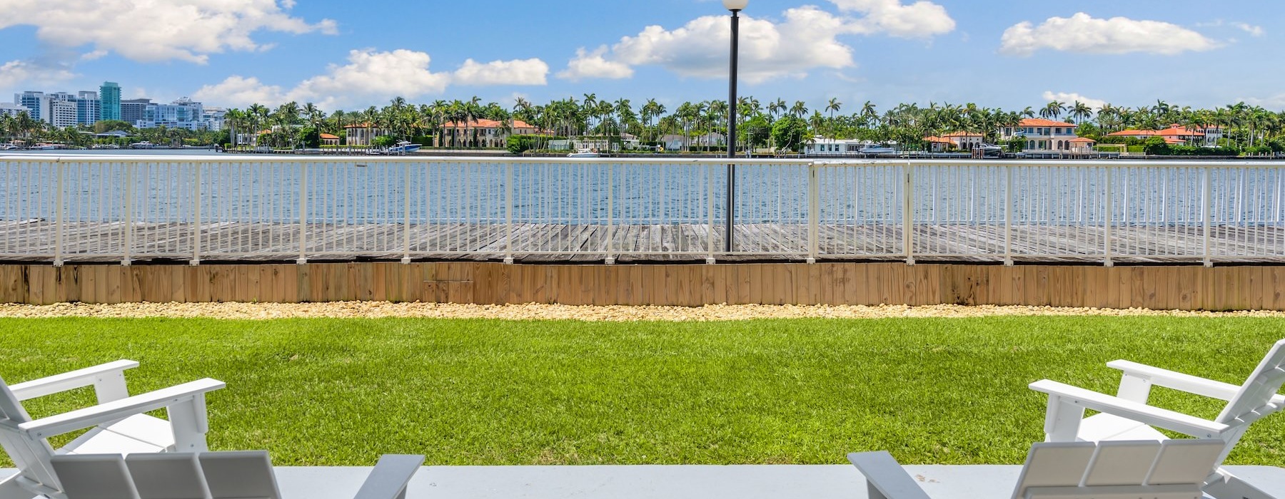 white chairs by a lawn and a view of a body of water